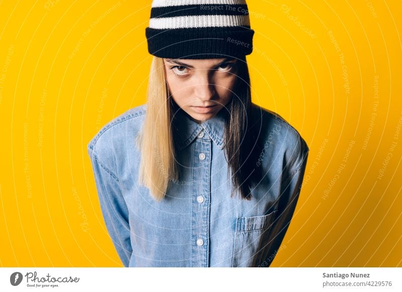 Serious Girl Wearing Hat Portrait studio yellow background portrait looking at camera expression colorful hair style casual young girl female serious