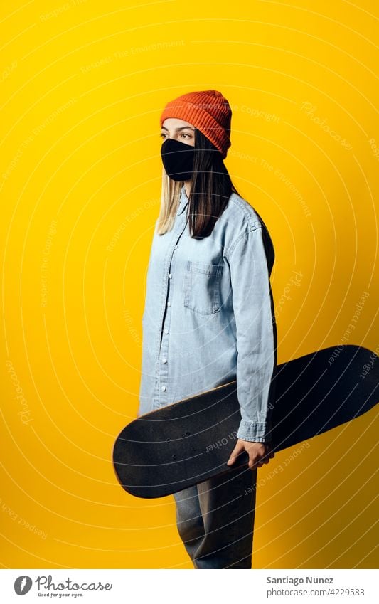 Girl With Skateboard Portrait studio yellow background portrait looking at front expression colorful hair style casual young girl female serious two colors hair