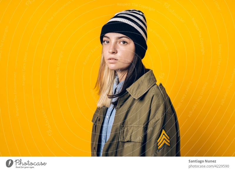 Girl Wearing Hat Portrait studio yellow background portrait looking at camera expression colorful hair style casual young girl female serious two colors hair