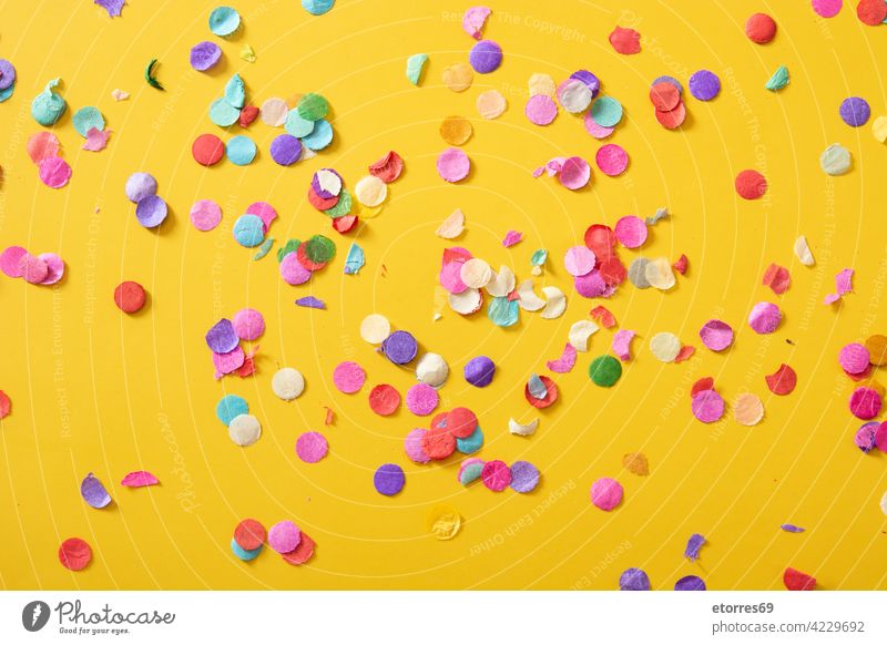 Colorful confetti on yellow background celebration party birthday blue adoration bright circle color colorful concept copyspace decoration decorative greeting