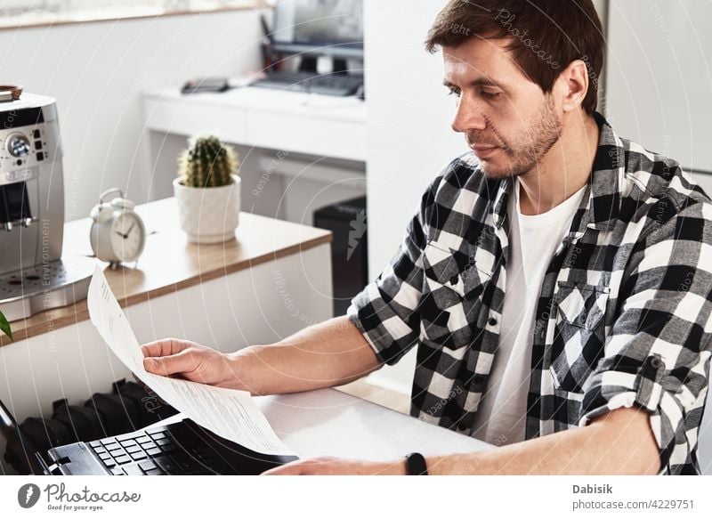 Man works at home office with laptop and documents man business workplace indoors computer laptop business portrait businessman casual company confident