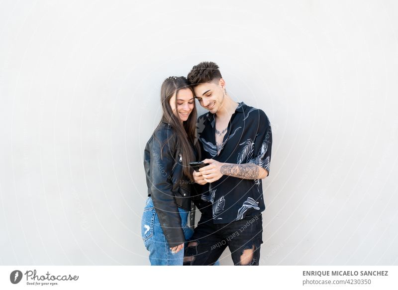 Couple looking at mobile on white background together phone smartphone love wireless male mobile phone people smiling affection connection friends girlfriend
