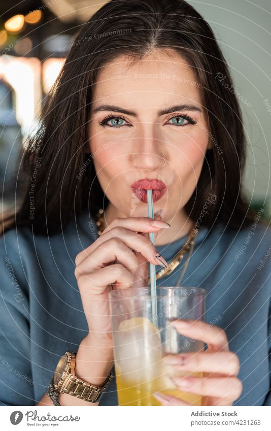 Woman enjoying cold soft drink in cafe woman happy beverage fizzy straw refreshment sip carefree cheerful lifestyle positive casual young pleasure female break