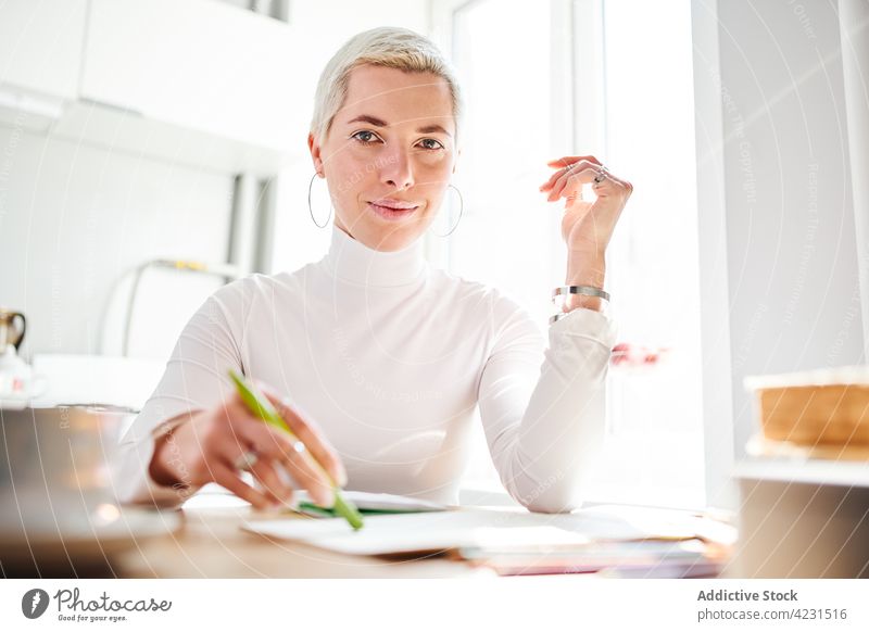 Astrologer laughing at table in light house astrologer positive feminine carefree accessory charismatic woman home portrait content glad happy astrology