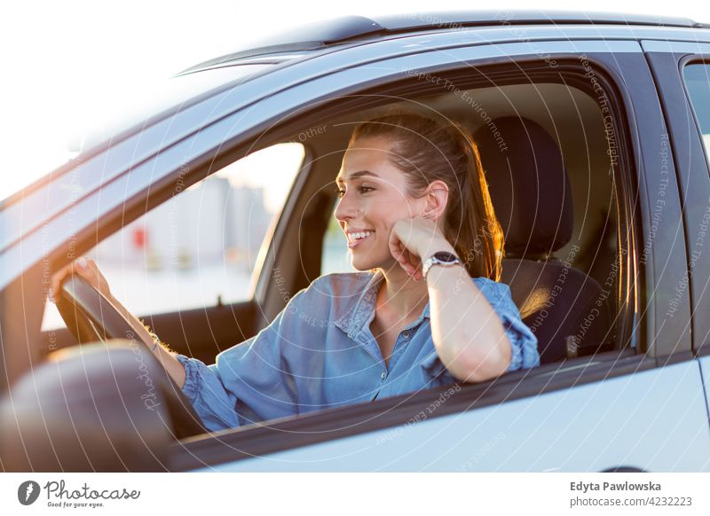 Happy woman driving a car and smiling carsharing confident satisfaction female attractive beautiful young adult joy positive content sitting driver owner
