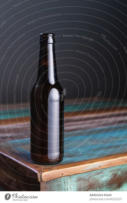 Bottle of beer on old table in house bottle alcohol drink beverage painted natural minimal wooden material glass alcoholic minimalism square shape floor home