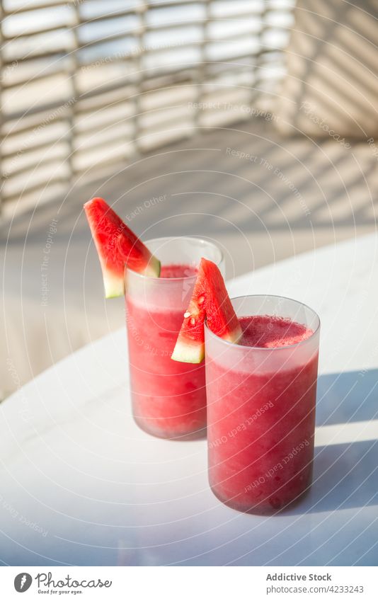 Glasses of appetizing watermelon juices placed on table on patio smoothie fresh refreshment healthy sofa beverage vitamin drink natural summer fruit slice tasty