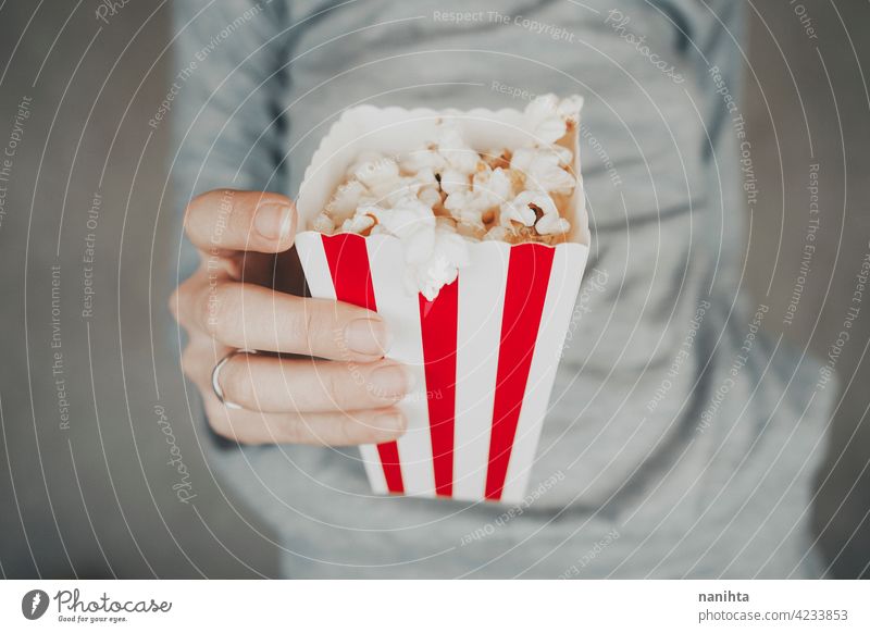 Woman holding a container full of pop corn cinema film vintage retro classic classy red white temptation snack woman enjoy hand lifestyle people food delicious