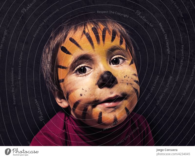 5 year old girl with tiger face painted by herself. Looking at camera with a cute expression Hallowe'en Child Painting (action, artwork) Joy Family & Relations