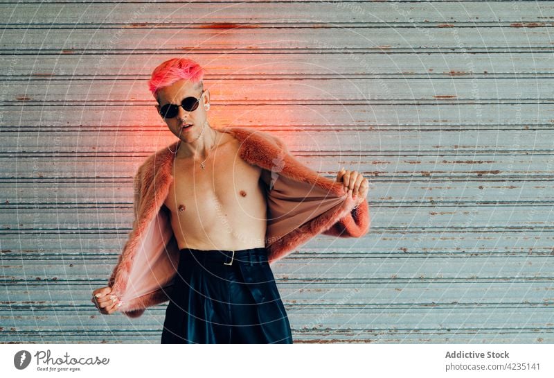 Homosexual model with naked torso on gray background homosexual fashion style individuality accept gender man portrait gay cool haircut fur jacket shirtless