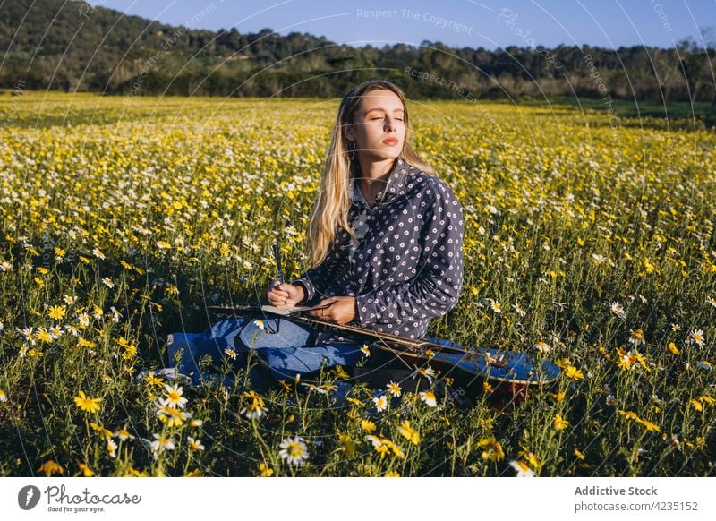 Young female playing guitar on nature woman summer countryside write hipster musician dreamer eyes closed notebook summertime lifestyle romantic meadow vacation