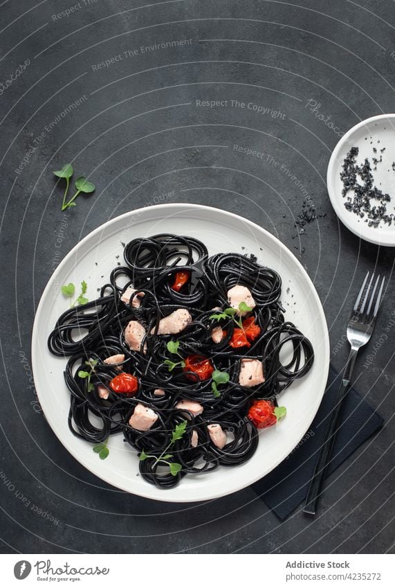 Black ink spaghetti with salmon cherry tomatoes black pasta black spaghetti italian spaghetti eating noodles culinary basil meal food plate dish healthy dinner