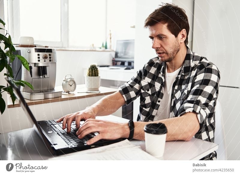 Man works at home office with laptop and documents man business workplace indoors computer laptop business portrait businessman casual company confident