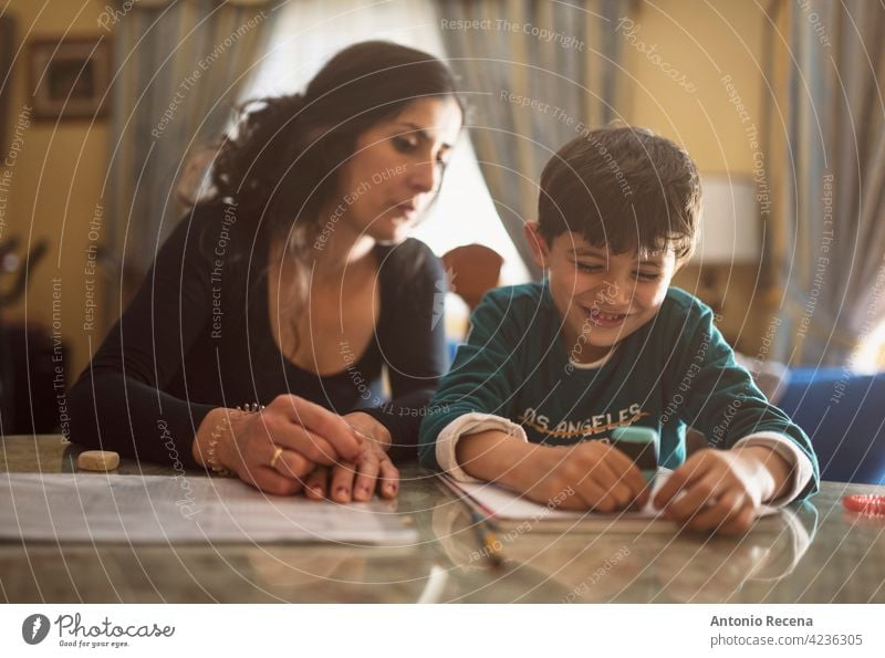 Mother and son doing homework mother people person indoor lifestyles happy write boy caucasian child childhood education indoors learning love mid adult woman