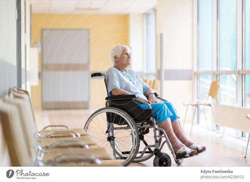 Senior woman sitting in wheelchair in hospital one person loneliness lonely alone wheel chair disability physical impairment Handicapped mobility support