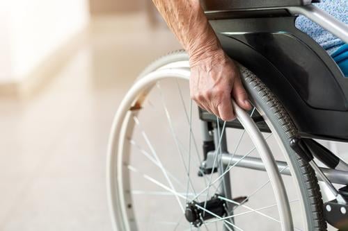 Senior person sitting in wheelchair unrecognizable person close-up hand one person loneliness lonely alone wheel chair disability physical impairment