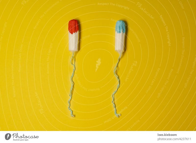 Tampons soaked in blue and red fluid as concept of uncomfortable female truth shown in advertisements for mentruation products menstruation tampon hygiene