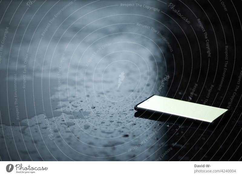 a cell phone lies on a table Cellphone smartphone Table Lie Bad weather Rainy weather Wet Drops of water Mobile