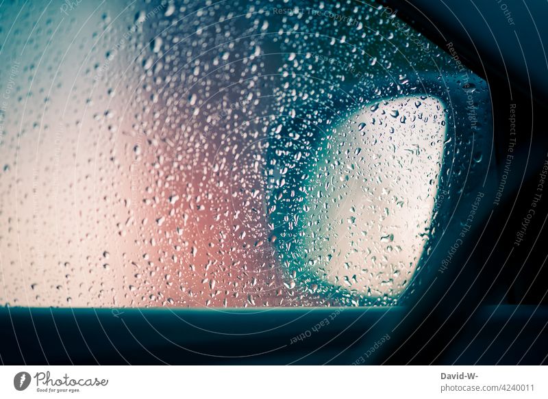 Raindrops on a car window Rainy weather raindrops Bad weather Car window Storm Road traffic Autumn Wet Drops of water car mirrors Window pane side window