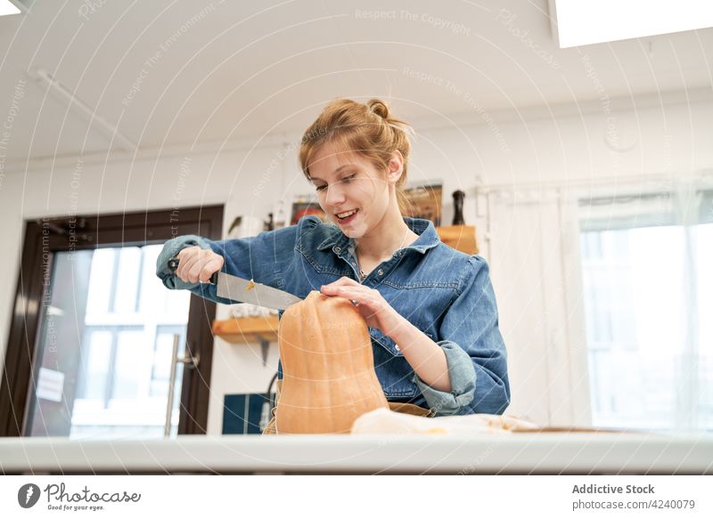Woman cutting fresh pumpkin at table in house woman vegetable culinary recipe knife kitchen home squash raw whole vegetarian product natural chopping board