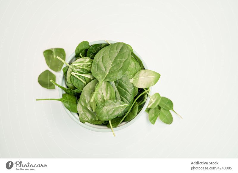 Fresh spinach leaves in bowl on white background leaf vegetable healthy food vegetarian natural product organic fresh ingredient vein green color pile stem