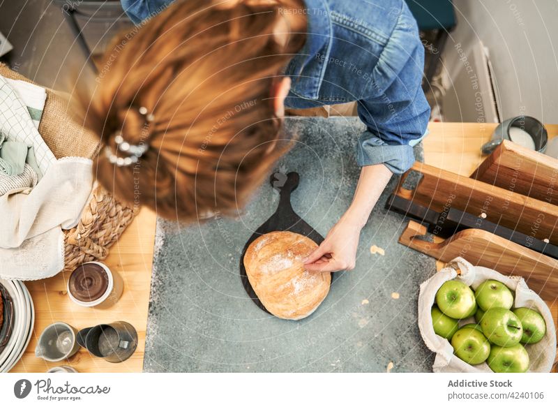 Faceless woman sprinkling bread with flour in kitchen sprinkle baked fresh recipe culinary prepare homemade crust wheat apple fruit vitamin juicy cook