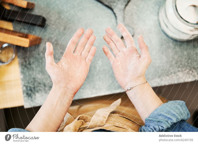 Crop woman with flour on hands at home palm cook dry ingredient apron show line demonstrate prepare organic product natural domestic house feminine bracelet