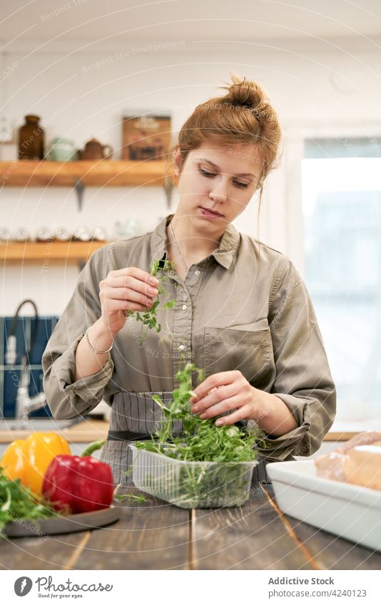 Woman with cress sprigs in container in house kitchen woman herb healthy food vegetable recipe culinary cook portrait pepper bright plastic box chicken poultry