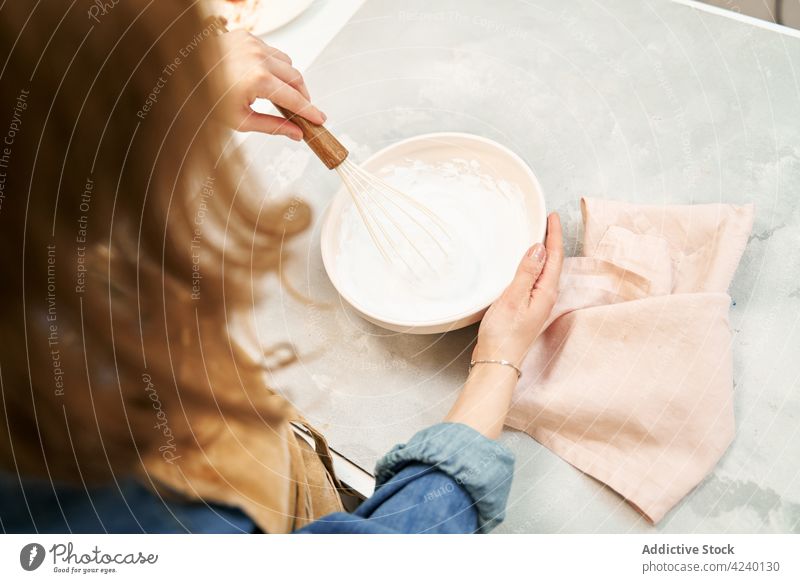 Smiling woman whipping frosting in kitchen at home culinary recipe cream cook sweet smile homemade bowl whisk utensil content satisfied charming process lamp