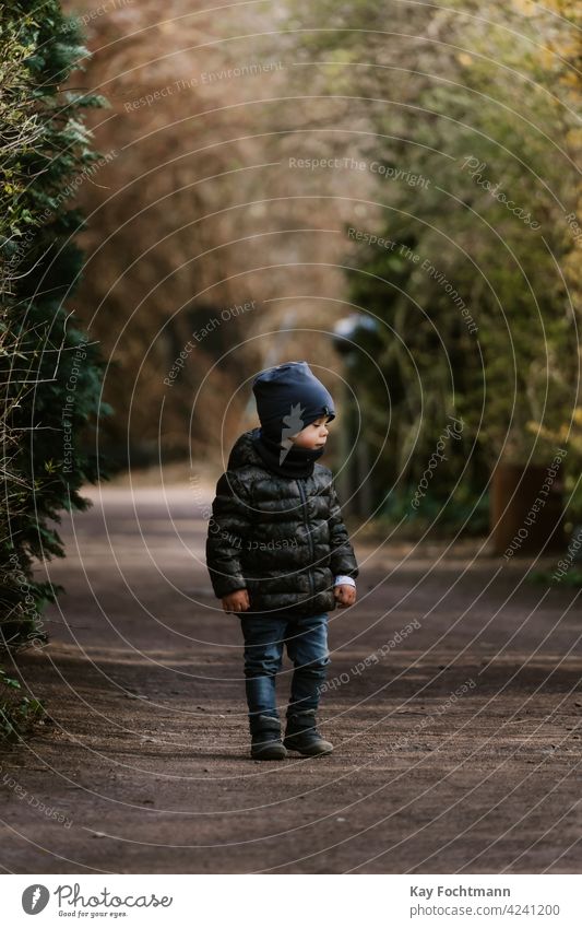 cute toddler standing on alleyway activity alone boy caucasian child child care childhood children closeup day daylight ethnicity family happy hat holiday
