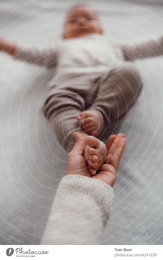 This has hand and foot, mother holds baby feet in hand Hand Baby Colour photo Child Small Infancy Girl Cute Happy pretty Caucasian Life cute Soft Innocent