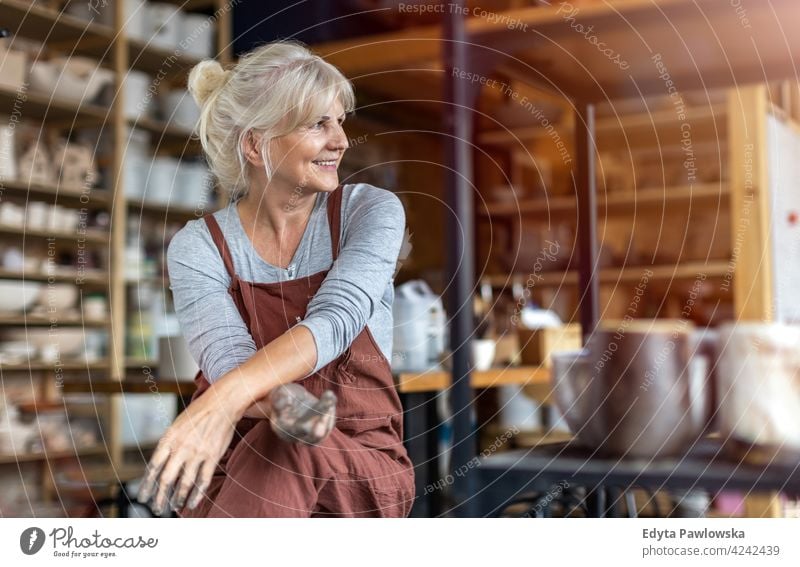Portrait of senior female pottery artist in her art studio ceramics work working people woman adult casual attractive happy Caucasian enjoying one person