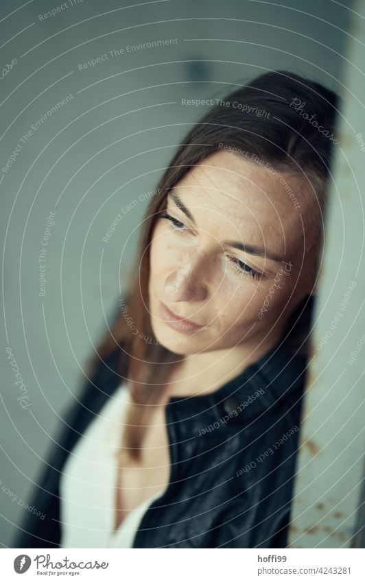 the woman averts her eyes thoughtfully 1 Young woman blurred background Emotions Face of a woman Brunette Women's eyes Think Moody Pensive sad Meditative