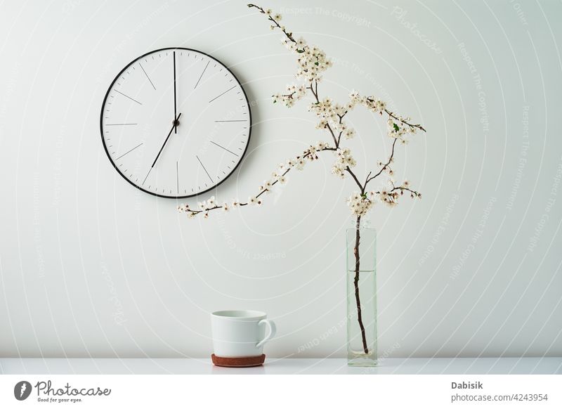 Wall clock, blooming branch and cup on white background - a Royalty Free  Stock Photo from Photocase