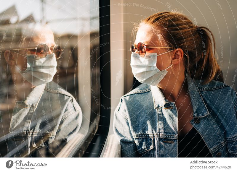 Woman in mask riding in train woman passenger transport commute protect covid 19 covid19 modern prevent ride window new normal coronavirus seat pensive
