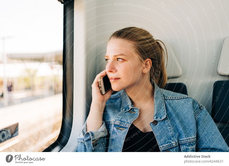 Calm lady speaking on phone riding in train woman ride passenger phone call smartphone window dream communicate transport conversation young talk mobile public