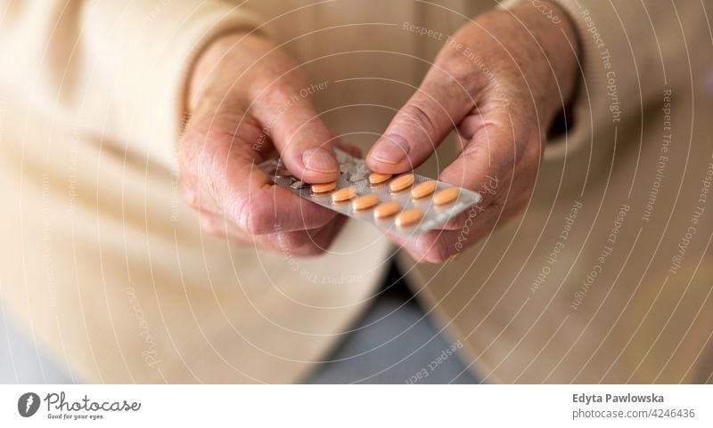 Senior woman about to take her medication people senior mature casual female Caucasian elderly home house care old health healthcare nursing home aging