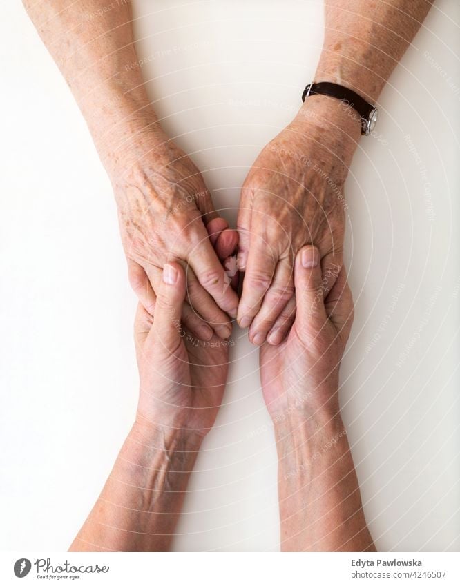 Woman holding a loved one's hand in support people woman senior mature casual female Caucasian elderly home house care health healthcare nursing home aging