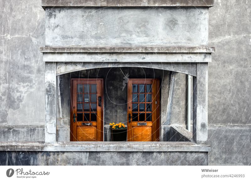 Warm looking wooden doors in a grey weathered facade, serving suggestion with flowers House (Residential Structure) Plaster Entrance Wood Gray warm Appealing