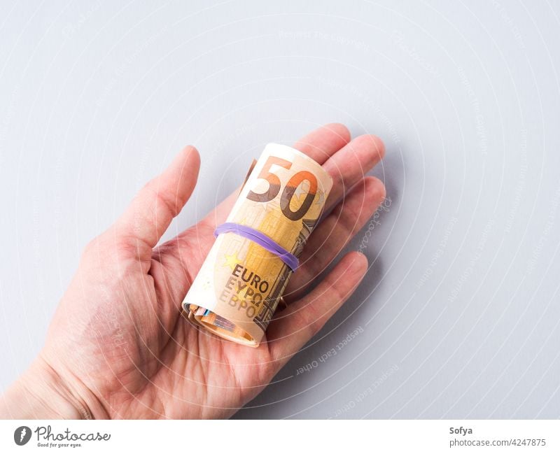 Euro 50 value banknotes roll with rubber on gray background euro money cash pay 50 euro savings investment hand income cost exchange economy tax currency