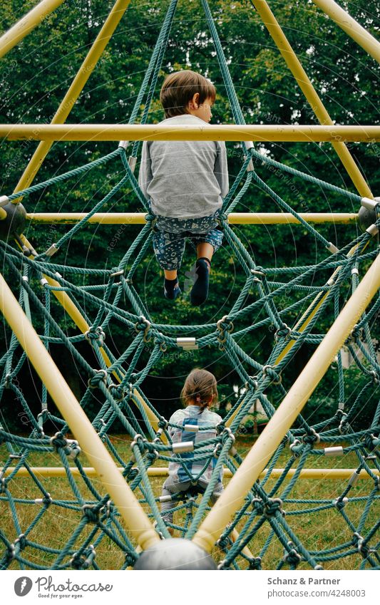 Two children sitting together on a climbing frame climbing scaffold Sit Child Infancy Family family life Playground Playing Colour photo Day Leisure and hobbies