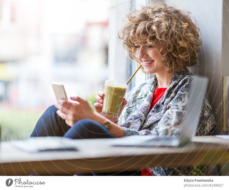 Young woman with mobile phone in cafe enjoying lifestyle young adult people one person casual caucasian positive carefree happy smile smiling female attractive