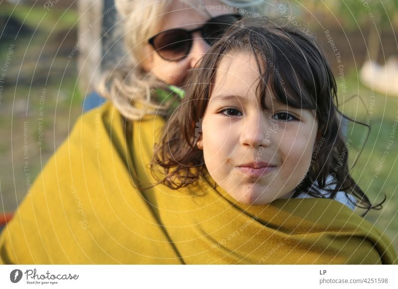girl in her mothers arms protected by a scarf Downward Looking Profile Upper body Portrait photograph Copy Space middle Copy Space bottom Copy Space top