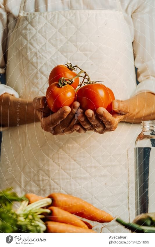 Woman holding tomatoes and vegetables over a table with water near her, healthy food concept with copy space peace biology cleaning climate change close up