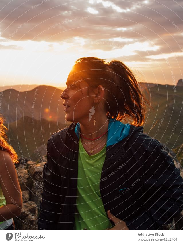 Woman with friend hiking in mountain hike woman trekking sunset sky cloud nature together sundown travel relationship traveler valley tourism carefree dusk