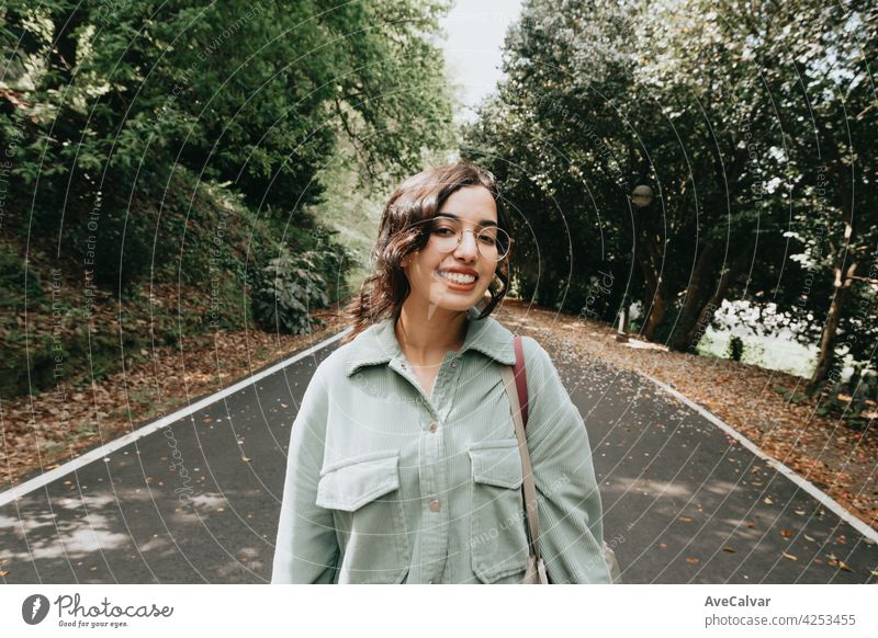 Young Moroccan woman smiling to camera in autumnal and desaturated colors with copy space and modern clothes curly hipster teenager female moroccan young
