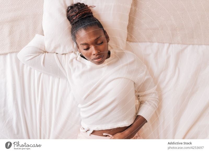 Young black woman sleeping on comfy bed at home eyes closed relax lying bedroom pillow asleep morning calm cozy female young african american ethnic human face