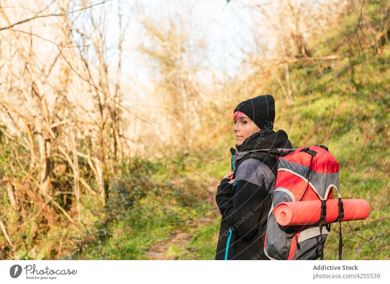 Cheerful woman standing in nature during hiking hike trekking trip forest adventure hiker tourism journey backpack travel female traveler warm clothes