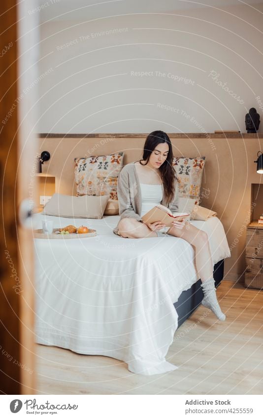 Serene woman reading book on soft bed bookworm bedroom serene interesting enjoy story comfort hobby calm tranquil at home sit breakfast lifestyle novel cozy