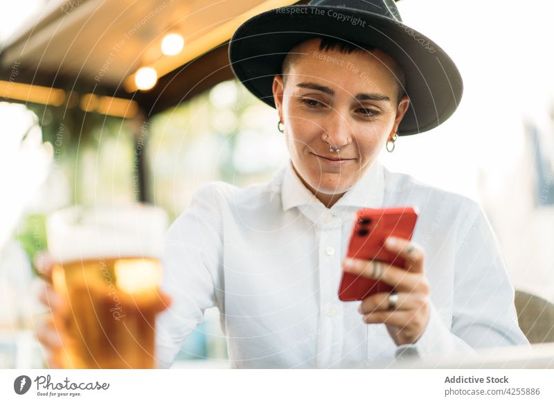 Tomboy with smartphone in cafe woman tomboy identity queer weird alternative stare style female transgender gadget neutral extraordinary unique agender youth